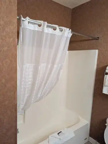A guest bathroom with a shower and tub