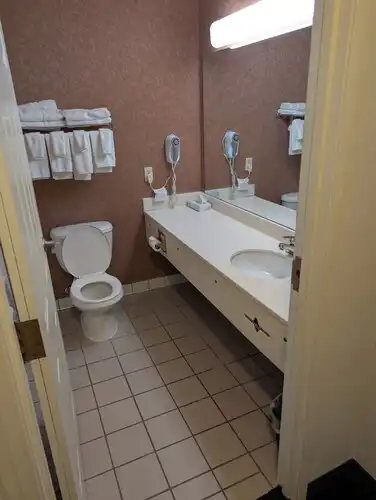 A guest bathroom vanity with towels and a hairdryer